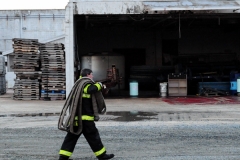 1.19.11..Patricia Hildenbrand Photo..a firefighter carries a hose to the fire trucks as they work to put out a blaze that damaged the main warehouse of the Black Gold Potato Farm in Rhodesdale. Fourteen fire companies and one hundred firefighters responded to the three-alarm fire.  No injuries have been reported and the cause of the fire is still under investigation.